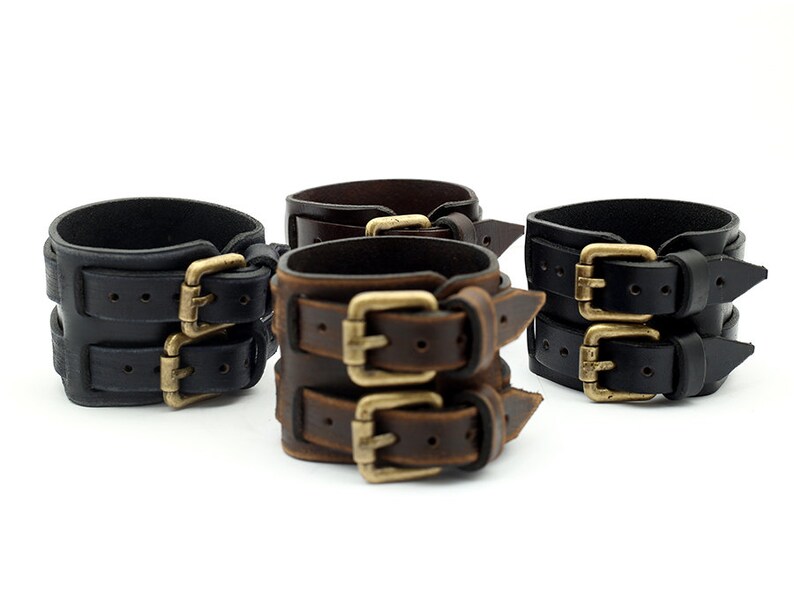 Puede incluir: Tres pulseras de cuero con hebillas dobles. Una pulsera es de cuero negro, otra de cuero marr&oacute;n y la &uacute;ltima de cuero marr&oacute;n oscuro.