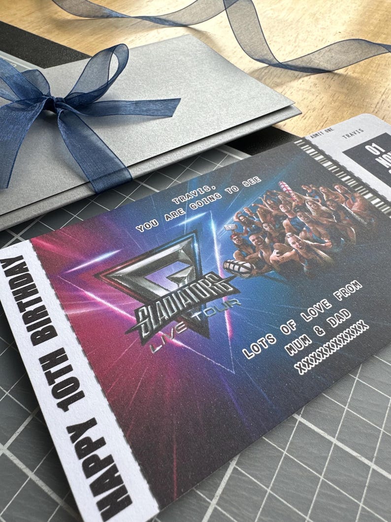 K&ouml;nnte beinhalten: Ein silberner Geschenkumschlag, der mit einem blauen Band gebunden ist, neben einem Konzertticket. Auf dem Ticket steht "Gladiators Live Tour" und "Happy 10th Birthday". Das Ticket hat ein farbenfrohes Design mit dem Text "Travis, You are going to see".