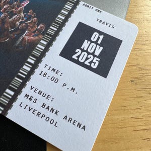K&ouml;nnte beinhalten: Ein Konzertticket f&uuml;r Travis, datiert auf den 01. November 2025 um 18:00 Uhr in der M&S Bank Arena, Liverpool. Das wei&szlig;e Ticket hat schwarzen Text und einen Barcode. Im Hintergrund ist eine Menschenmenge zu sehen.