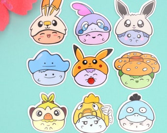 May include: Nine colorful cartoon character stickers featuring Pokemon characters. The stickers are round and feature various Pokemon characters wearing hats. The characters are drawn in a cute, cartoon style.