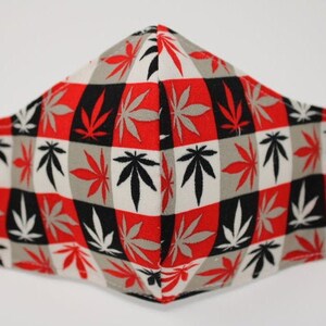 May include: Red, black and grey face mask with a chequered pattern and a repeated design of marijuana leaves.