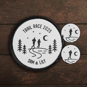 May include: White round patch with black text and design. The text reads "Trail Race 2025 Sam & Lily". The design features two figures running on a trail with trees and a crescent moon.
