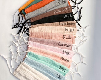 May include: A set of 15 face masks in various colors, including ivory, sky, mint, peach, pink, old rose, nude, beige, light brown, black, dark brown, gray, rust, olive, and burnt yellow. The masks are made of a soft, breathable fabric and have adjustable ear loops.