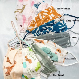 May include: Assortment of face masks with various patterns. Designs include pink flowers, butterflies, yellow and blue leaves, arrows, giraffes, dinosaurs, elephants, and other animals. Each mask has adjustable ear loops for a comfortable fit.