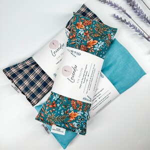 May include: Three lavender eye pillows with different fabric patterns. The pillows are filled with flax seed and organic lavender flowers. The text on the label reads "Lavender Eye Pillow Filled with flax seed and organic lavender flowers. Heat in microwave for 20-30 seconds. Can be steamed for 20-30 seconds.  SLINK CREATIONS CO."