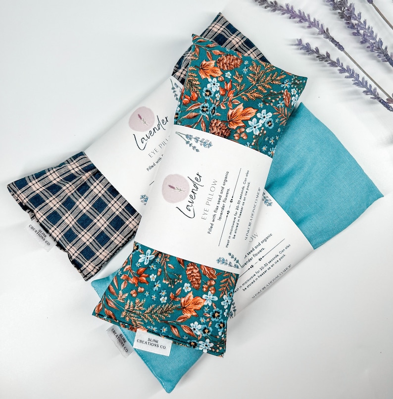 May include: Three lavender eye pillows with different fabric patterns. The pillows are filled with flax seed and organic lavender flowers. The text on the label reads "Lavender Eye Pillow Filled with flax seed and organic lavender flowers. Heat in microwave for 20-30 seconds. Can be steamed for 20-30 seconds.  SLINK CREATIONS CO."