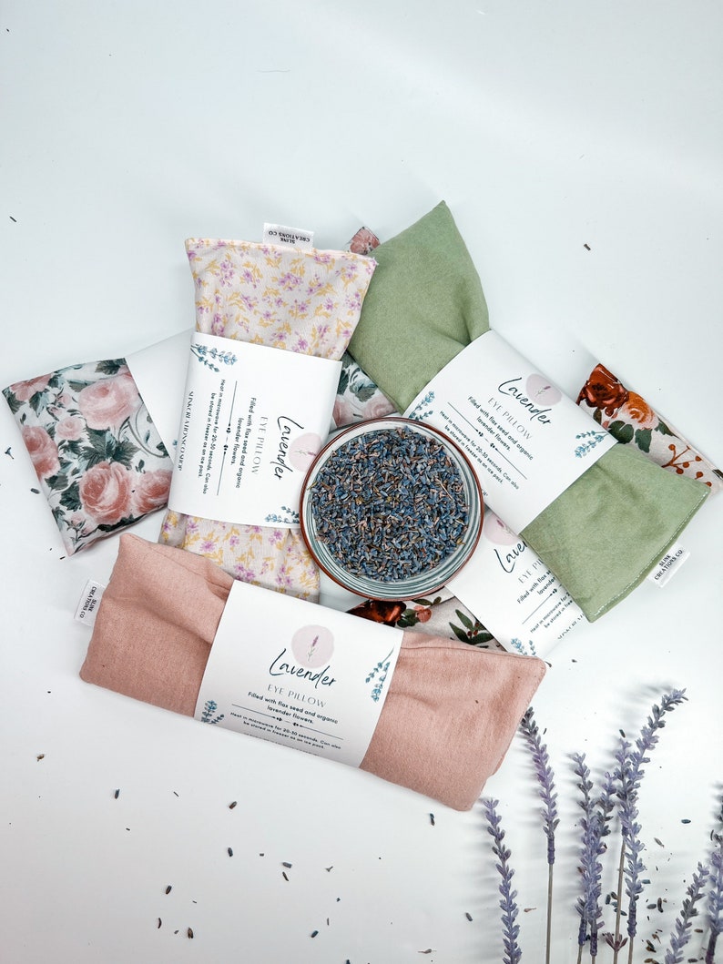 May include: Four lavender eye pillows with floral fabric covers. The pillows are filled with flax seed and organic lavender flowers. The text on the label reads "Lavender Eye Pillow Filled with flax seed and organic lavender flowers".