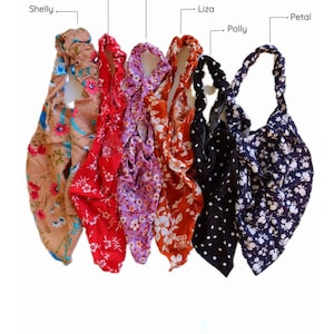May include: Six different patterned headbands in various colors, including beige, red, purple, orange, black, and navy blue. The headbands are made of fabric and have a gathered elastic band.