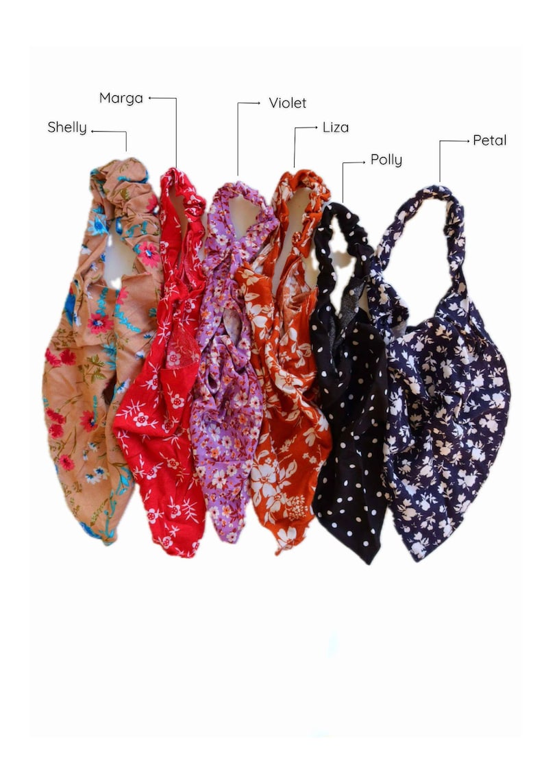 May include: Six different patterned headbands in various colors, including beige, red, purple, orange, black, and navy blue. The headbands are made of fabric and have a gathered elastic band.