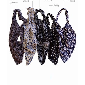 May include: Five different patterned headbands in black, white, and gray. The headbands are made of fabric and have a knotted design. The headbands are labeled "Lou", "Eloisa", "Stormy", "Polly", and "Petal".