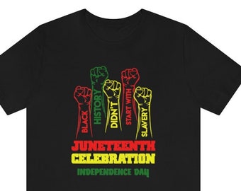 Può includere: T-shirt nera con un design grafico che celebra il Juneteenth. Il design presenta pugni alzati in rosso, verde e giallo, con il testo "Black History Didn't Start With Slavery" e "Juneteenth Celebration Independence Day."