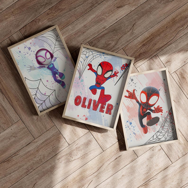 May include: Three framed prints with a watercolor background and black spiderwebs. The prints feature cartoon versions of Spider-Man in different poses. One print has the name "Oliver" written in red letters.