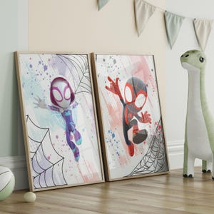 May include: Two framed prints featuring cartoon versions of Spider-Man characters. The print on the left features a female Spider-Man character with purple and white clothing, and the print on the right features a male Spider-Man character with red and black clothing. Both prints have a watercolor background with black and white spiderwebs.