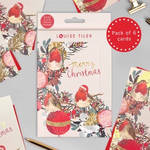 May include: A pack of six Christmas cards featuring a festive design with robins, berries, and a gold bauble. The cards are pink with gold foil accents and the text "Merry Christmas".