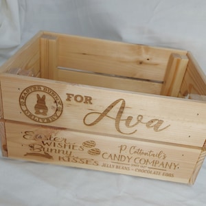 Könnte beinhalten: Eine Holzkiste mit dem Text "Easter Bunny Delivery" und einer Hasengrafik. Die Kiste ist mit dem Namen "Ava" und dem Text "Easter Wishes Bunny Kisses P. Cottontail's Candy Company. Since 1927 Jelly Beans - Chocolate Eggs" personalisiert.