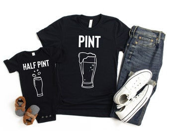 May include: A black t-shirt with the word "PINT" and a white outline of a beer glass. A black onesie with the words "HALF PINT" and a white outline of a smaller beer glass.