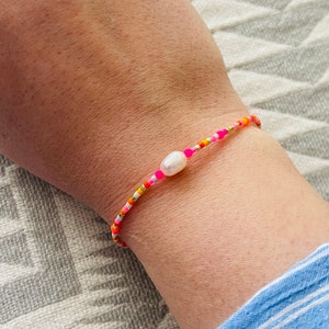 Armband Fein Makramee mit Neonperle Pink Orange Buntes Armband Minimalistisch mit Süßwasserperle oder Smiley. Bild 1