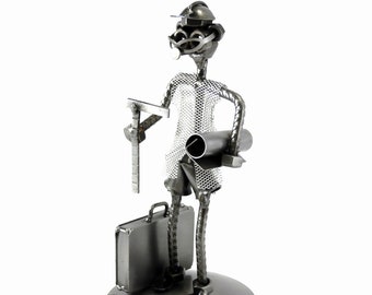 May include: A metal figurine of an architect holding a ruler, blueprints, and a briefcase. The figurine is made of recycled metal and has a rustic, industrial look.