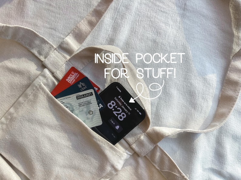 May include: A beige tote bag with an inside pocket. The pocket contains a credit card and a smartphone with the time 8:28 displayed on the screen. The text "INSIDE POCKET FOR STUFF!" is written on the bag.