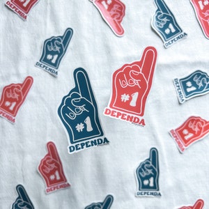 May include: A white surface with multiple blue and red foam finger cutouts. The fingers are pointing up and have the word "DEPENDA" written on them. Each finger has the number "#1" written on it.