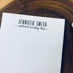 May include: White notepad with the text "JENNIFER SMITH" and "optional wording here" in black.
