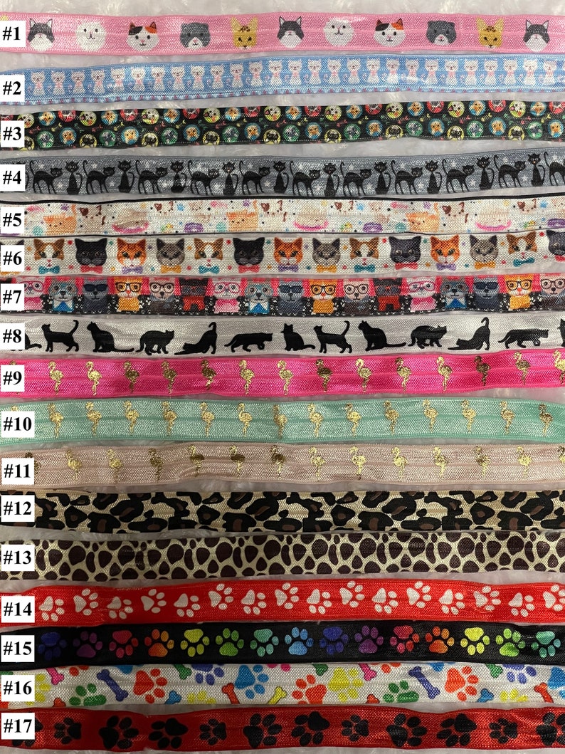 Op de afbeelding: Een set van 17 kleurrijke elastiekjes voor haar met verschillende patronen, waaronder katten, flamingo's, pootjes en luipaardprint.