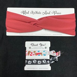 May include: Two colorful hair scrunchies with a dachshund and paw print designs. The scrunchies are packaged on a white card with the text "Thank You! Thanks for Being An Awesome Vet Tech!" and the website address "redwhiteandpaw.com".