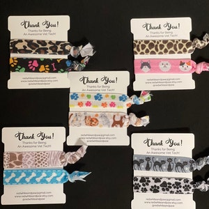 Op de afbeelding: Set van vier haar elastiekjes met verschillende dierenprint ontwerpen. Elk elastiekje is gemaakt van twee lagen stof en wordt geleverd met een klein kaartje waarop staat "Bedankt! Bedankt dat je een geweldige dierenartsassistent bent!" en contactgegevens van de verkoper.