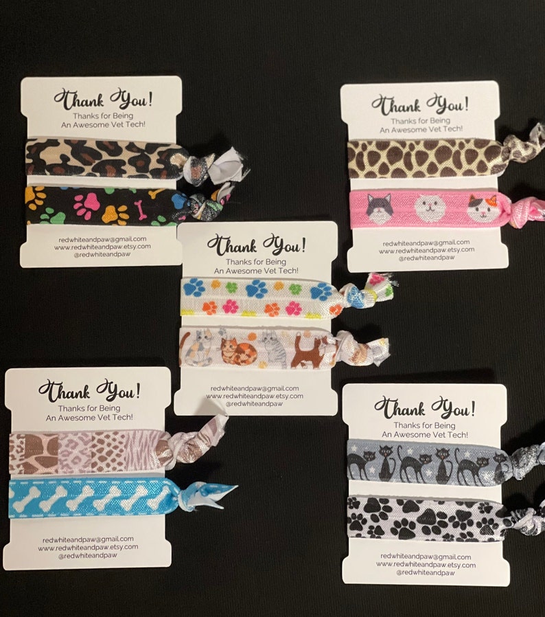 Op de afbeelding: Set van vier haar elastiekjes met verschillende dierenprint ontwerpen. Elk elastiekje is gemaakt van twee lagen stof en wordt geleverd met een klein kaartje waarop staat "Bedankt! Bedankt dat je een geweldige dierenartsassistent bent!" en contactgegevens van de verkoper.