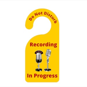 May include: Yellow door hanger with the text "Do Not Disturb" and "Recording In Progress".  Two microphones are pictured, one with the text "On The Air".