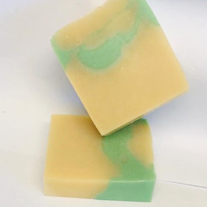 May include: Two bars of handmade soap with a swirl of green and beige. The soap is made with natural ingredients and is perfect for sensitive skin.
