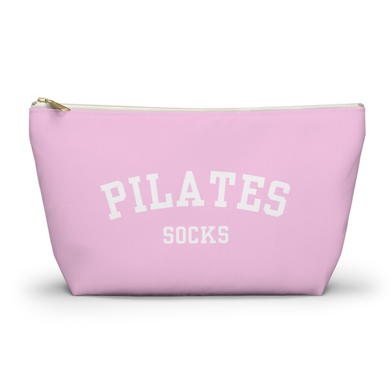 May include: A pink zippered pouch with the text "PILATES SOCKS" in white.