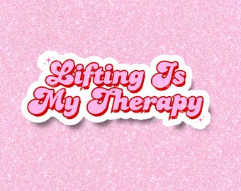 May include: Pink and red sticker with the text "Lifting Is My Therapy" in a retro font.