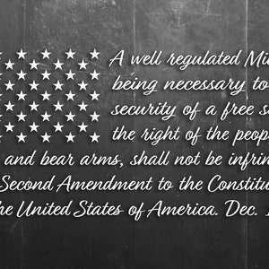 May include: A black chalkboard with white text that reads "A well regulated Militia, being necessary to the security of a free state, the right of the people to keep and bear arms, shall not be infringed. The Second Amendment to the Constitution of the United States of America. Dec. 1791". There is a white star pattern in the top left corner of the chalkboard.