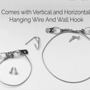May include: A close-up of picture hanging hardware, including metal brackets, hanging wire, screws, and a wall hook. The text "Comes with Vertical and Horizontal Hanging Wire And Wall Hook" is at the top of the image.