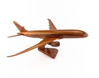 Könnte beinhalten: Detailliertes Holzmodellflugzeug mit brauner Oberfläche. Das Modell verfügt über Flügel, Leitwerk und einen Ständer. Das Design umfasst sichtbare Fenster und Motordetails, die das Wesen eines Flugzeugs einfangen.