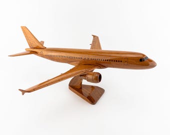 Könnte beinhalten: Detailliertes Holzmodell eines Flugzeugs mit polierter, warmbrauner Oberfläche. Das Modell verfügt über aufwendige Flügel- und Leitwerksdesigns, einen detaillierten Rumpf und ist auf einem passenden Holzständer montiert. Das Flugzeugmodell ist ein Dekorationsartikel.