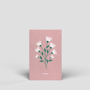 Op de afbeelding: Een rechthoekige wenskaart met een oudroze achtergrond en een centrale illustratie van witte bloemen met groene stelen en bladeren. Het woord DANKE staat in witte hoofdletters onderaan in het midden van de kaart gedrukt.