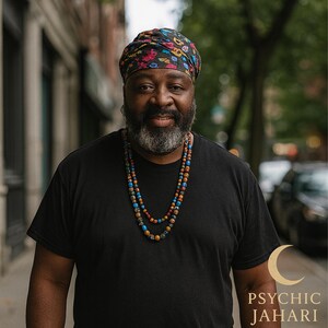 May include: A person wearing a black t-shirt, a multi-colored patterned headwrap, and a double-strand necklace featuring small, round, multi-colored beads. The text "PSYCHIC JAHARI" appears in the bottom right corner with a crescent moon icon.