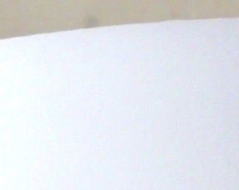 May include: A white lampshade with a smooth, rounded top.