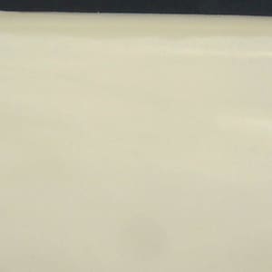 May include: A close-up of a smooth, off-white surface. The surface is slightly curved and appears to be made of a soft material.