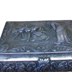 Vintage embossed repousse spelter footed jewellery box with red interior,