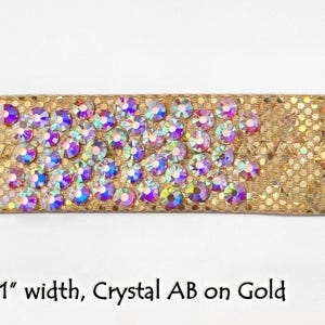 May include: Gold fabric trim with a row of iridescent crystal rhinestones. 1" wide.
