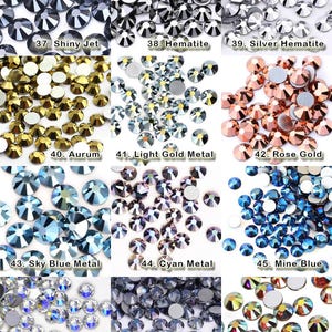 K&ouml;nnte beinhalten: Eine Sammlung von zw&ouml;lf verschiedenen Gruppen runder, facettierter Strasssteine in verschiedenen Farben und Ausf&uuml;hrungen, beschriftet von 37 bis 48, darunter Shiny Jet, Hematite, Silver Hematite, Aurum, Light Gold Metal, Rose Gold, Sky Blue Metal, Cyan Metal, Mine Blue, Moonlight, Ghost Light und Morning Light.