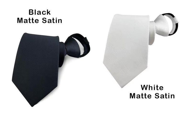 K&ouml;nnte beinhalten: Zwei Krawatten, eine aus schwarzem mattem Satin und eine aus wei&szlig;em mattem Satin. Jede Krawatte hat ein spitzes Ende und eine geknotete Halsschlaufe. Der Text "Black Matte Satin" steht &uuml;ber der schwarzen Krawatte, "White Matte Satin" darunter.