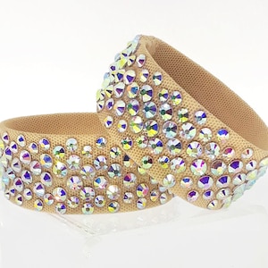 May include: Two beige fabric dance bracelets with iridescent rhinestones.