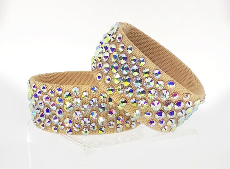May include: Two beige fabric dance bracelets with iridescent rhinestones.