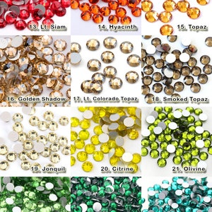 K&ouml;nnte beinhalten: Eine Sammlung von zw&ouml;lf verschiedenen Gruppen runder, facettierter Glas-Strasssteine in diversen Farben, nummeriert von 13 bis 24, darunter Rot-, Orange-, Gelb-, Braun-, Gr&uuml;n- und Blaut&ouml;ne, jeweils mit einer flachen, silberfarbenen R&uuml;ckseite.