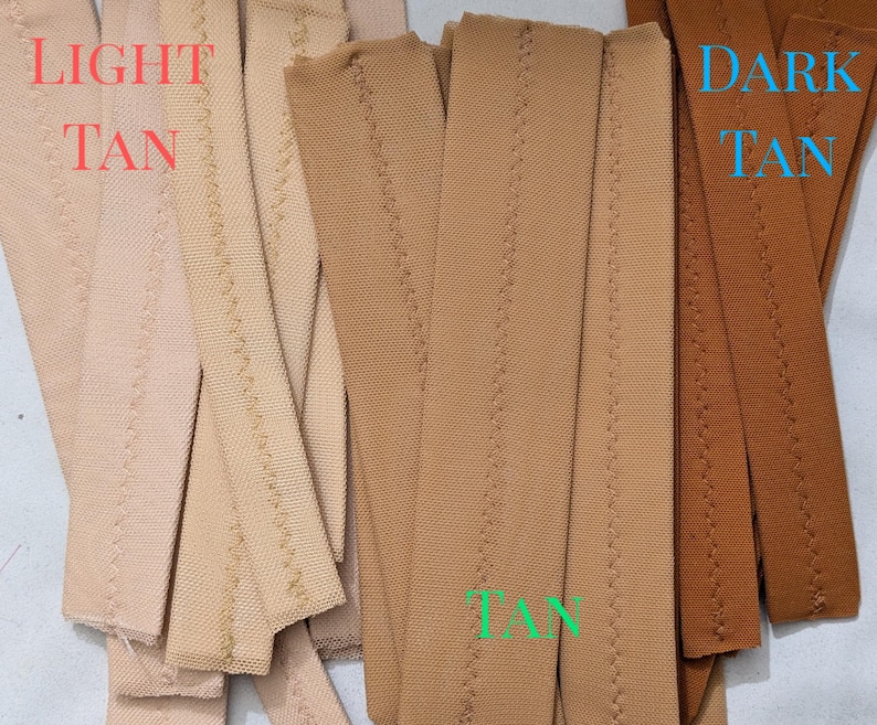May include: Two stacks of fabric strips, one light tan and one dark tan. The strips are sewn with a zig-zag stitch.