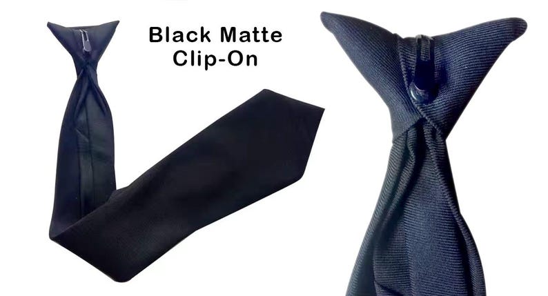K&ouml;nnte beinhalten: Eine schwarze, matte Clip-Krawatte aus einfarbigem, dunklem Stoff mit strukturierter Oberfl&auml;che. Der obere Teil enth&auml;lt einen funktionalen schwarzen Kunststoff-Clip zur Befestigung. Der Text Black Matte Clip-On ist im Bild zu sehen.